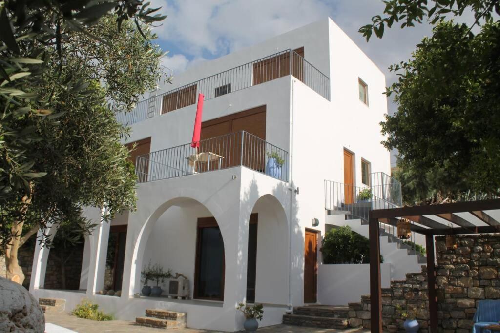 a white house with a red flag on it at A Crystal Clear House in Pyrgos, Heraklion Crete in Pírgos