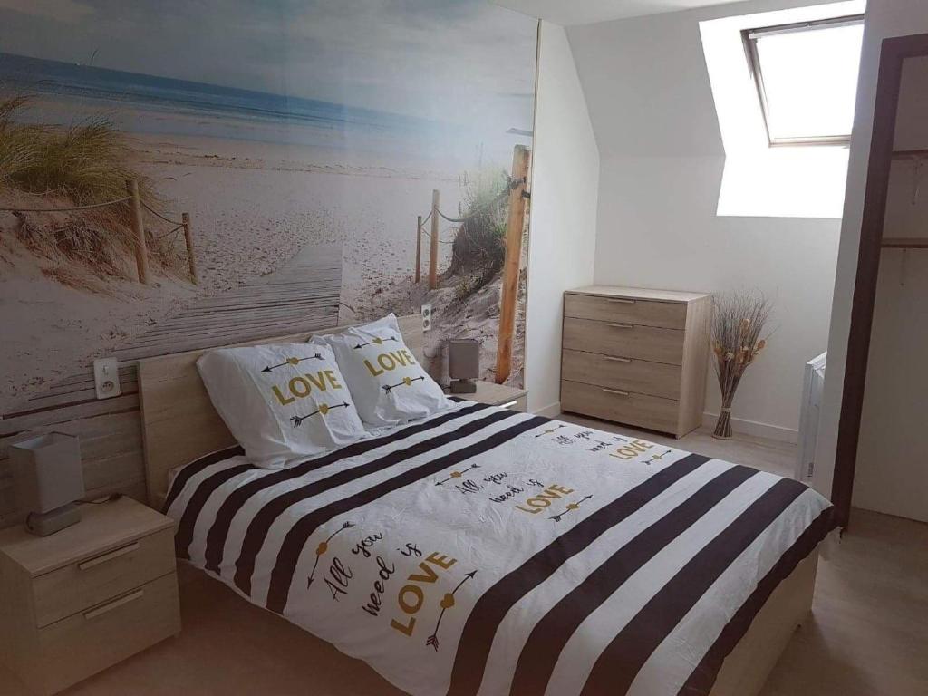 a bedroom with a bed with a beach mural on the wall at La Mouette in Beauvoir