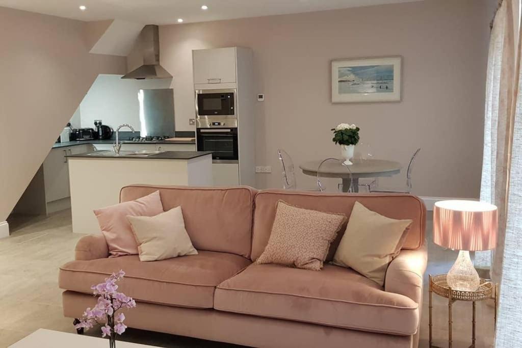 a living room with a brown couch and a kitchen at Kiln Cottage in Fareham