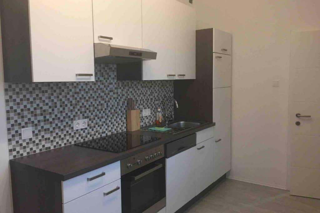 a kitchen with white cabinets and a black counter top at HAUS mit 3 Schlafzimmer und Garten in Amstetten