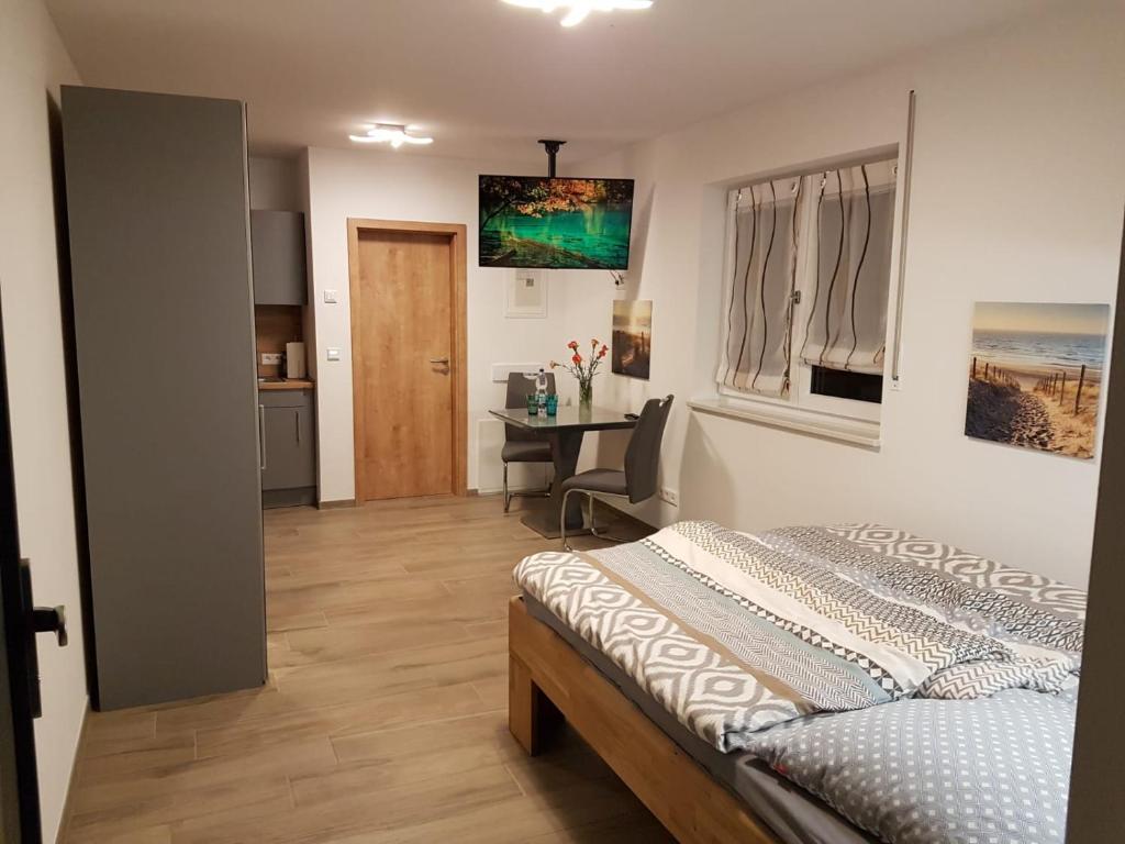 a bedroom with a bed and a desk in it at Casa Lago Ferienappartements Steinberg am See in Steinberg am See
