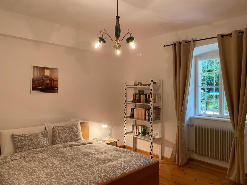 Un dormitorio con una cama y una estantería. en Cozy Apartment in a Historic Villa, en Merano