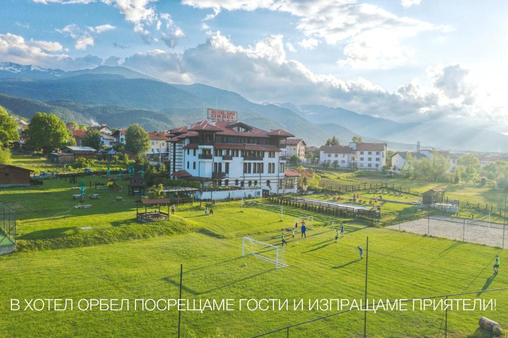 Un groupe de gens jouant au football sur un terrain dans l'établissement Hotel Orbel, à Dobrinichte