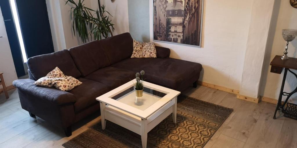a living room with a brown couch and a coffee table at Ferienwohnung/Monteurwohnung am Badesee bei Kassel in Weimar