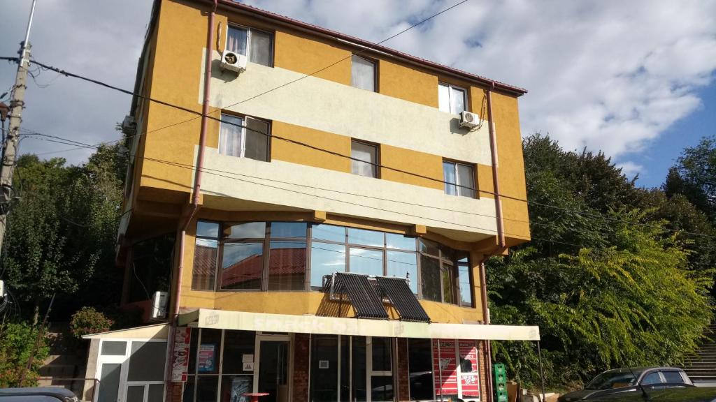 un gran edificio amarillo con ventanas en una calle en La Conu Iancu, en Drobeta-Turnu Severin