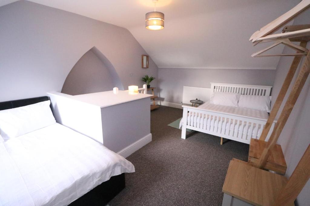 a bedroom with two white beds and a staircase at Amaya Five - Newly renovated - Very spacious - Sleeps 6 - Grantham in Grantham
