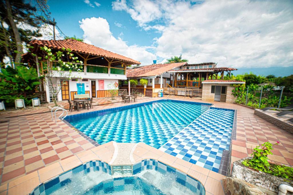 a swimming pool in front of a house at Eco Hotel las Palmas in Armenia
