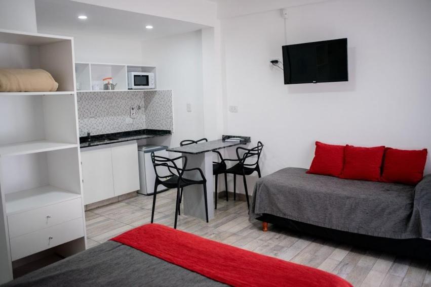 Un dormitorio con una cama y una mesa y una cocina. en Aurelia, en Valeria del Mar