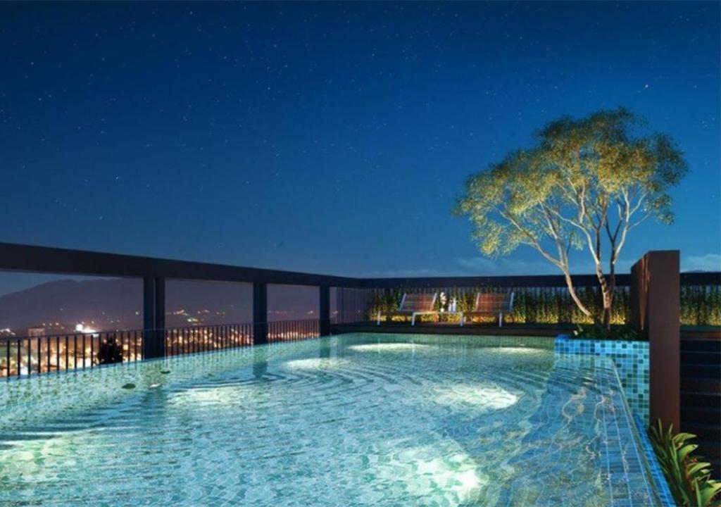 una piscina por la noche en un edificio en Cozy, Great location at heart of Nimman Rd., en Chiang Mai