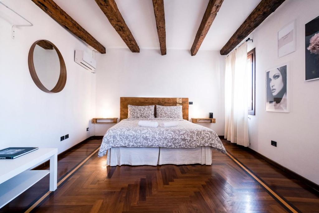 - une chambre avec un lit et un miroir mural dans l'établissement Ai Sogni, à Venise