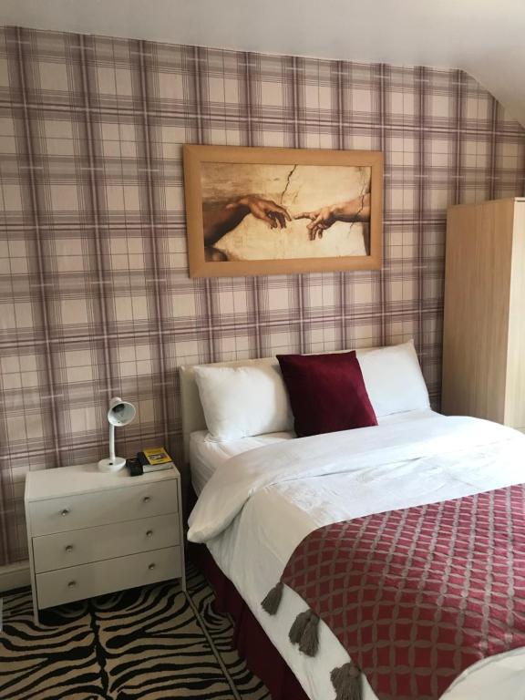 マンチェスターにあるRosewood lodgings Special offer for student on long stayのベッドルーム1室(ベッド1台付)が備わります。壁には絵画が飾られています。