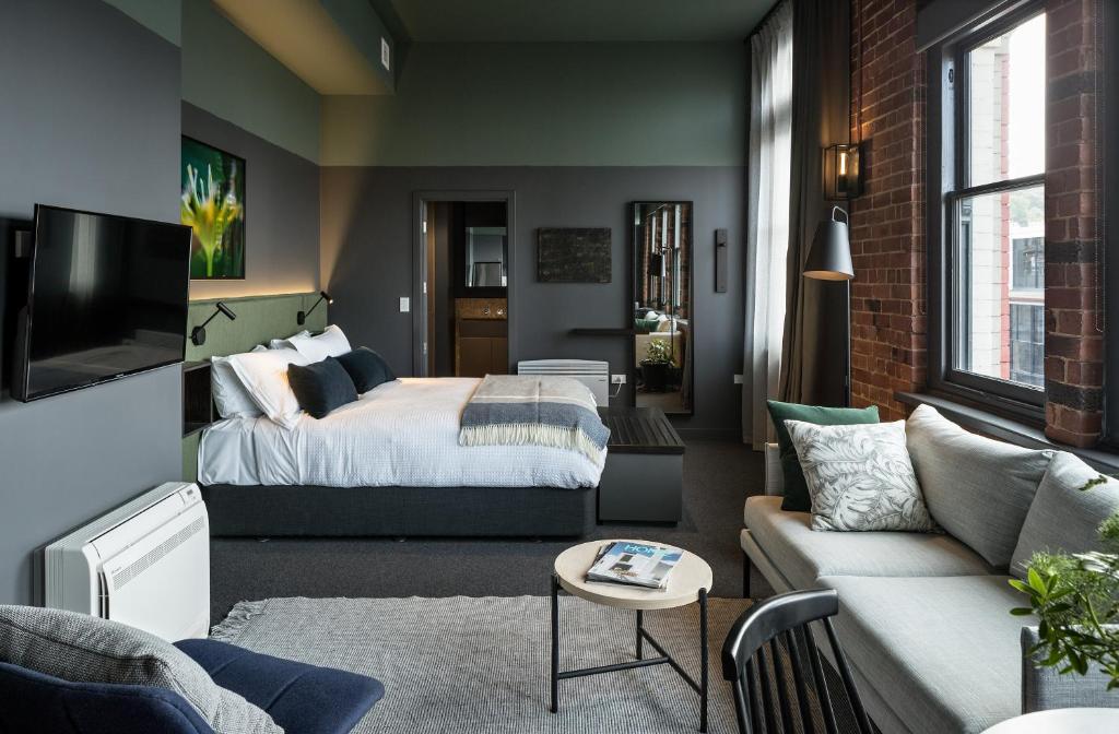 a bedroom and living room with a bed and a couch at The Chamberson in Dunedin