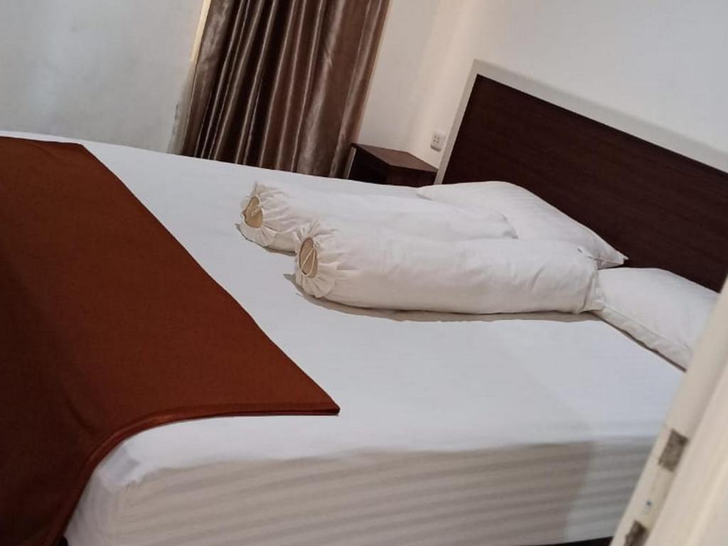 Un dormitorio con una cama con almohadas blancas. en Fidelia Homestay Palu Mitra RedDoorz, en Biromaru