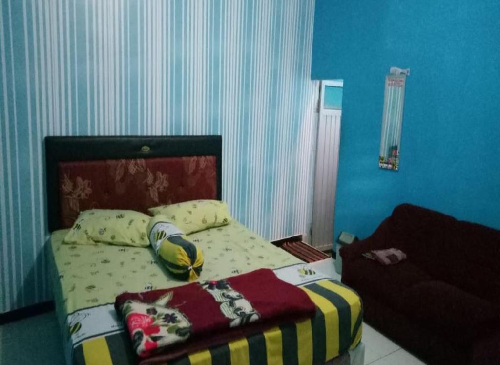 Un dormitorio con una cama con una manta. en Villa Vander en Pasuruan