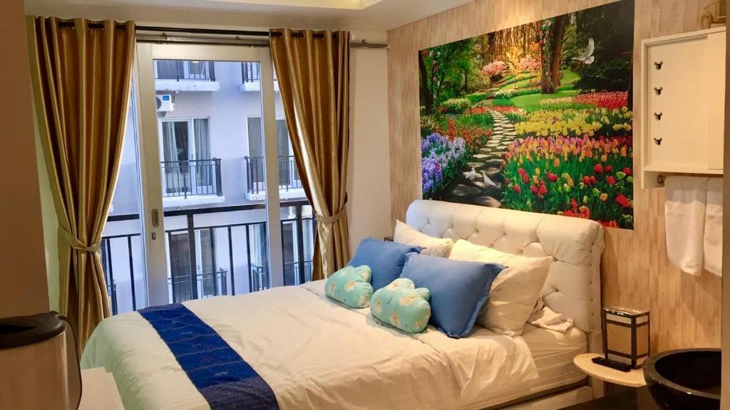 a bedroom with a painting on the wall at Apartment Grand Asia Afrika Tulip Bandung in Bandung