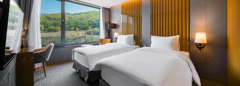 Postel nebo postele na pokoji v ubytování Jeongseon Intoraon Hotel
