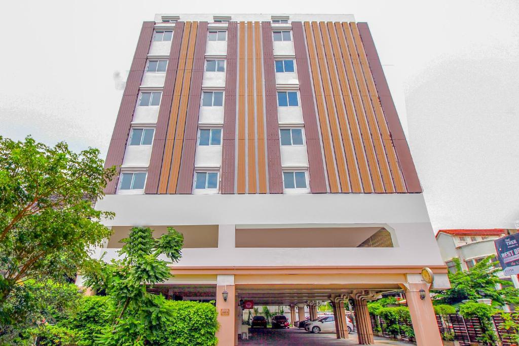 a tall building with orange and white at Capital O 411 Grandview Condo 15 in Bangkok