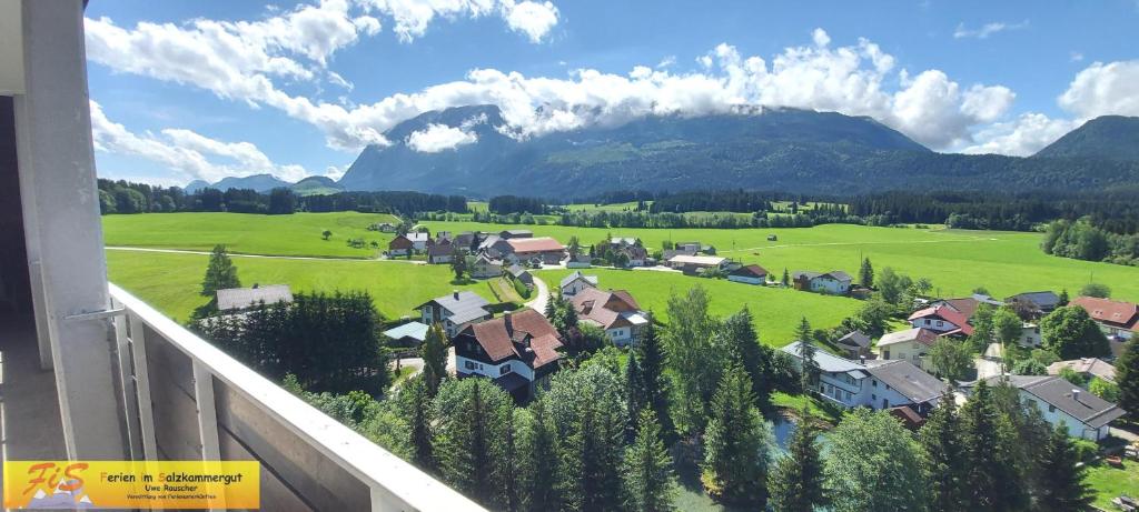 einen Balkon mit Blick auf ein Dorf mit einem Berg in der Unterkunft Apartment Panoramablick by FiS - Fun in Styria in Bad Mitterndorf