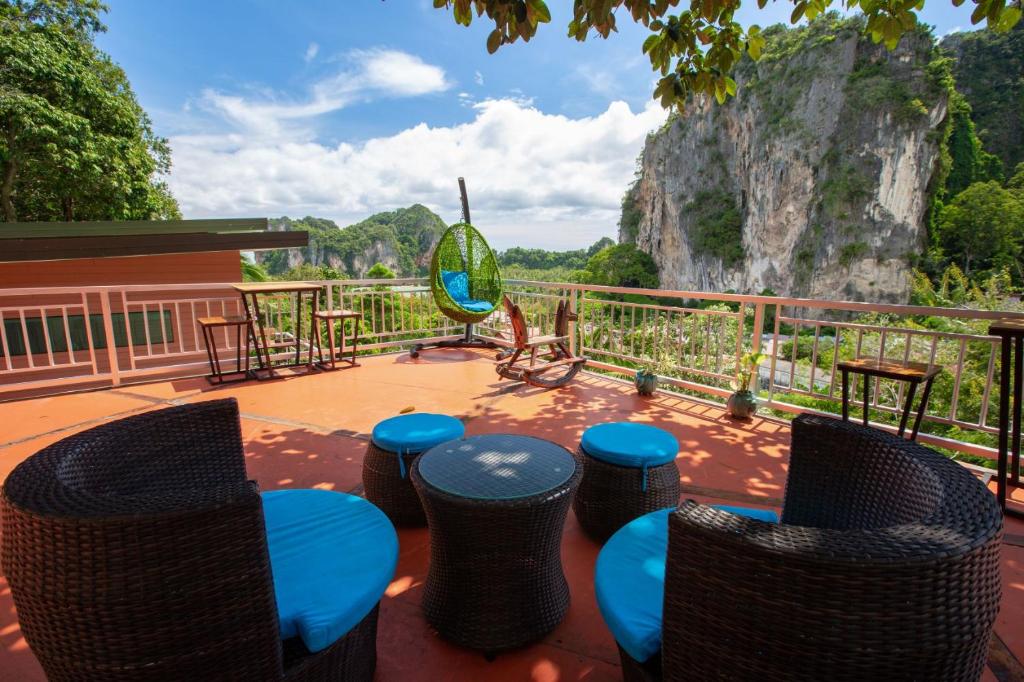 a patio with chairs and tables and a rock formation at Railay Hilltop in Railay Beach