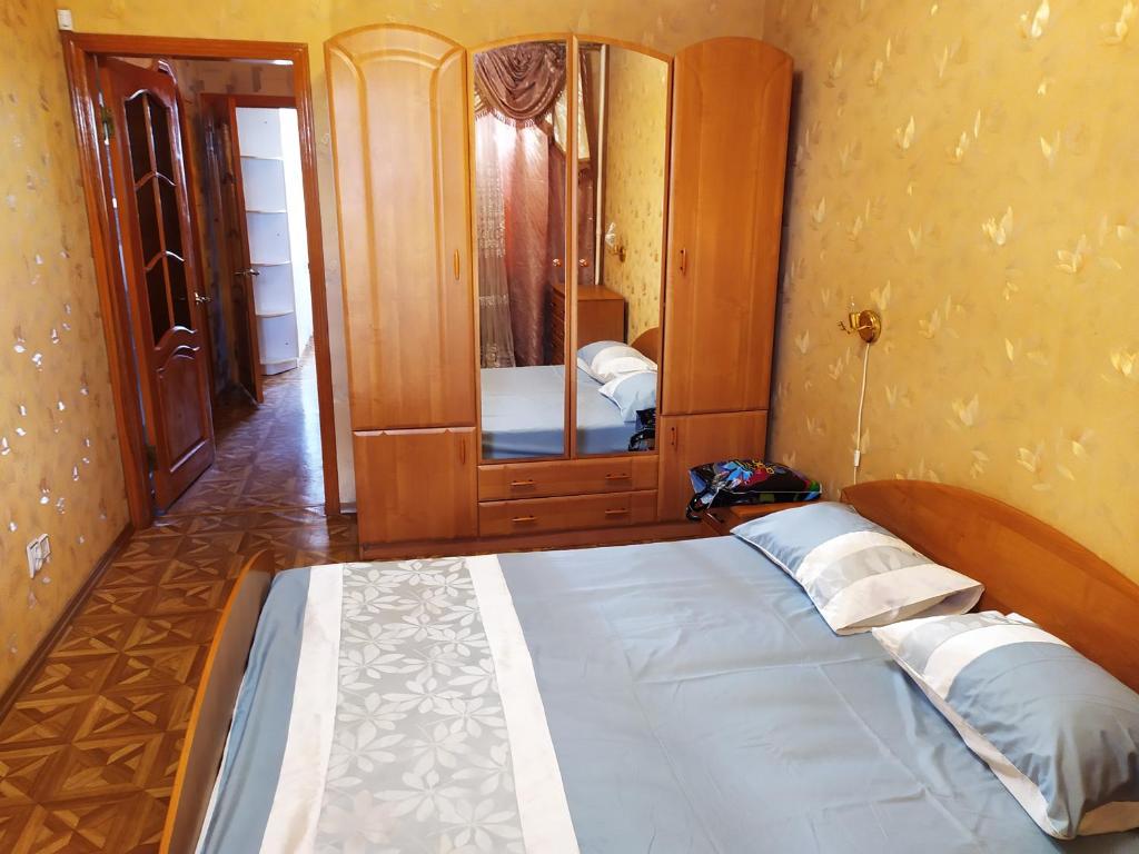 um quarto com uma cama grande e um espelho em Ильинская 3к посуточно почасово em Sumy