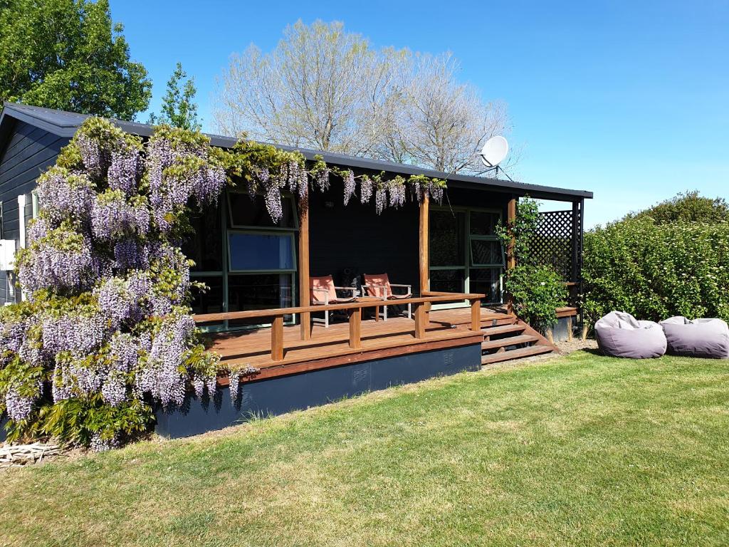 una casa con una corona de flores púrpuras. en Fairway Cottage, en Oamaru