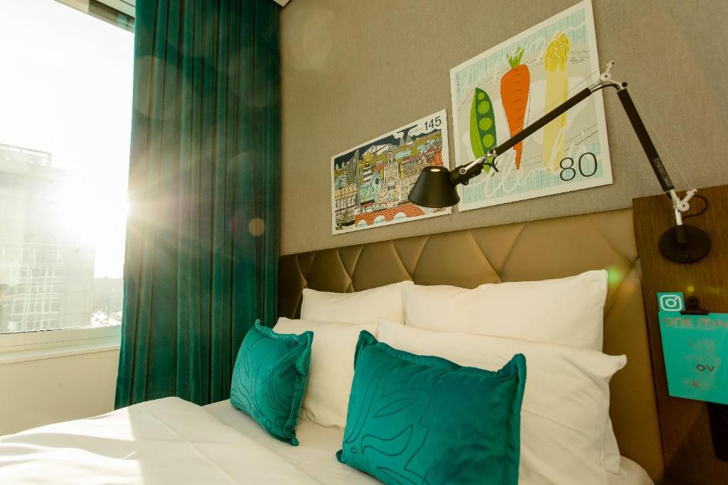 a bedroom with a bed with blue and white pillows at Motel One Leipzig-Post in Leipzig