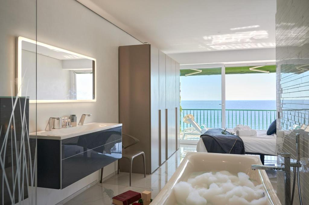 a bathroom with a tub and a view of the ocean at Sunlight Properties - Sky blue - 3 bedroom flat with sea view on the Promenade des Anglais in Nice
