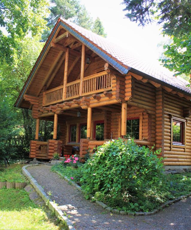 a log cabin with a porch and a balcony at Chalet mit Schlossblick Wernigerode, Chalet 2 in Wernigerode