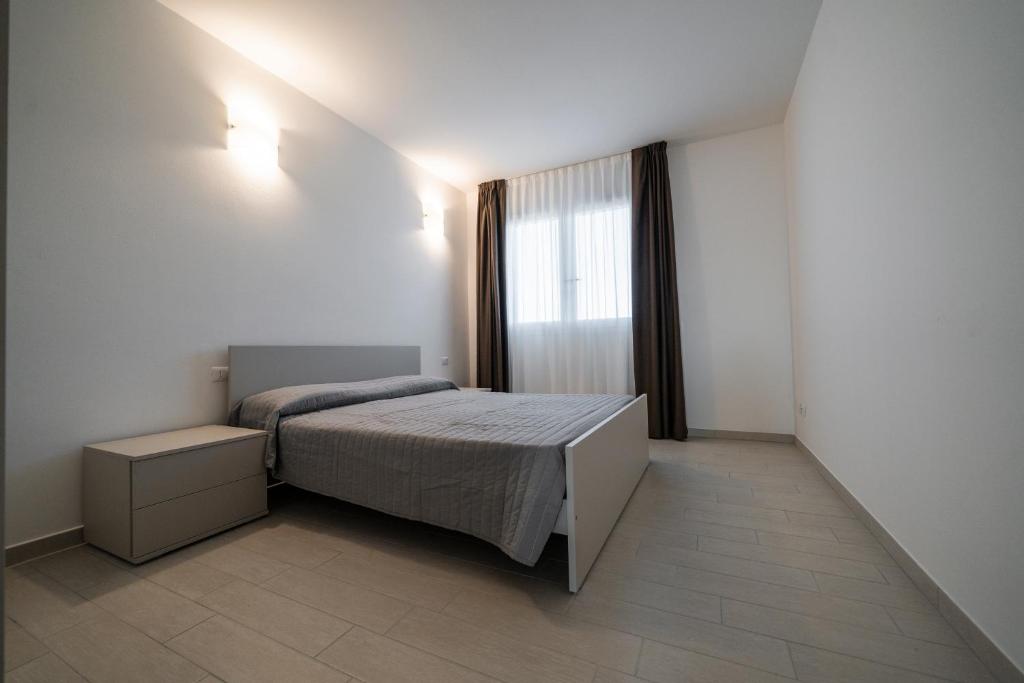 una piccola camera con letto e finestra di Sabbia & Mare a Rosolina Mare