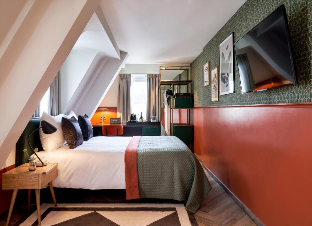 a hotel room with a bed and a tv at Park Centraal Den Haag in The Hague