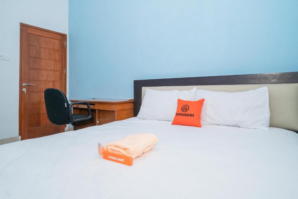 - une chambre avec un lit et une boîte dans l'établissement KoolKost @ Harapan Jaya Bekasi, à Bekasi