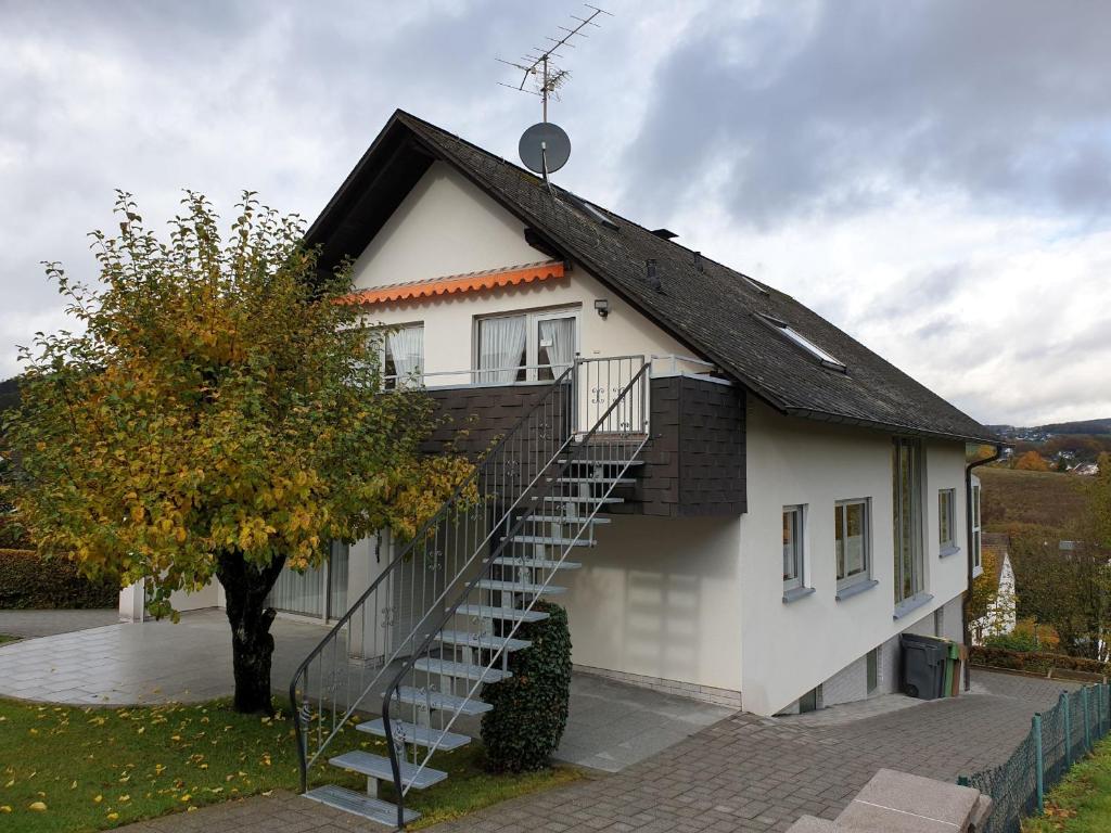 une maison blanche avec un escalier sur son côté dans l'établissement Ferienwohnung Wicker, à Attendorn