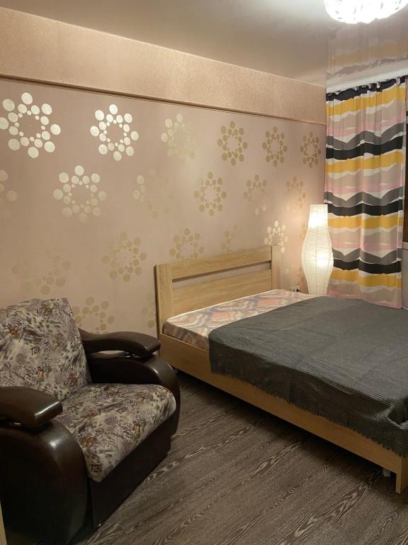 a bedroom with a bed and a chair at Аэропорт in Irkutsk