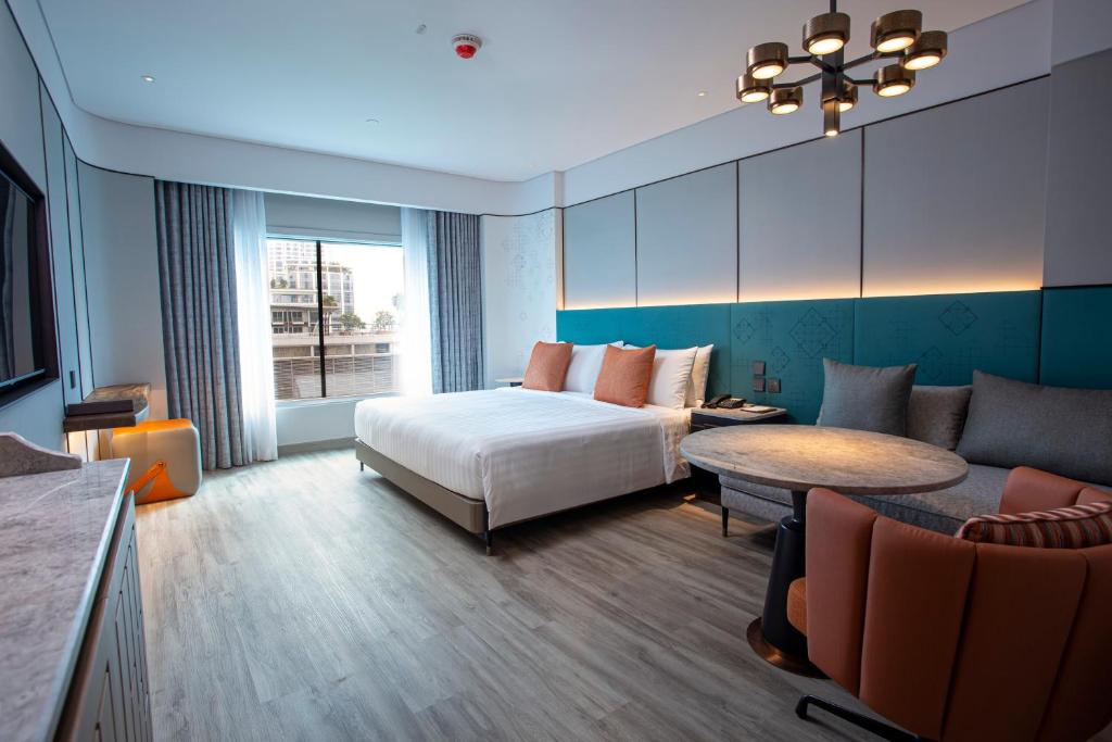 a hotel room with a bed and a couch at Amari Bangkok in Bangkok