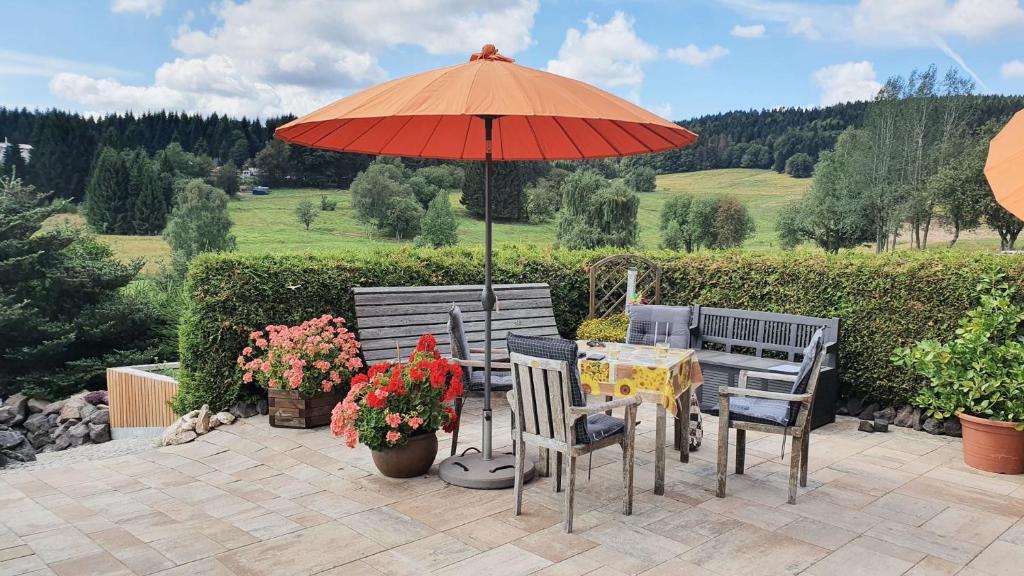 a table and chairs under an umbrella on a patio at Monis gemütliche Ferienwohnungen in Suhl