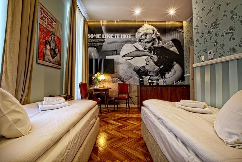 a hotel room with two beds and a poster of a woman at Stare Kino Cinema Residence in Łódź
