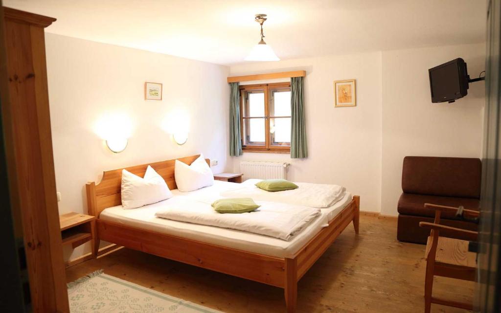 een slaapkamer met een bed met witte lakens en een raam bij Gasthaus zum Späth in Englmannsberg