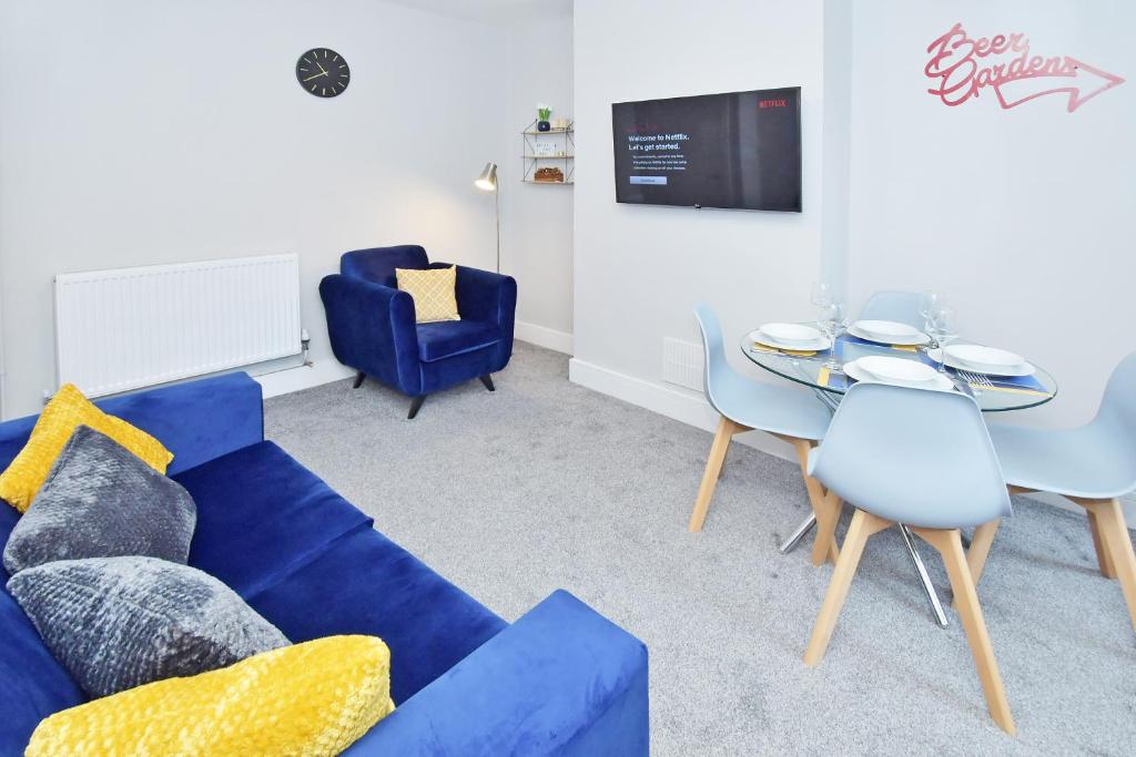 Townhouse @ 543 London Road Stoke في Trent Vale: غرفة معيشة مع أريكة زرقاء وطاولة