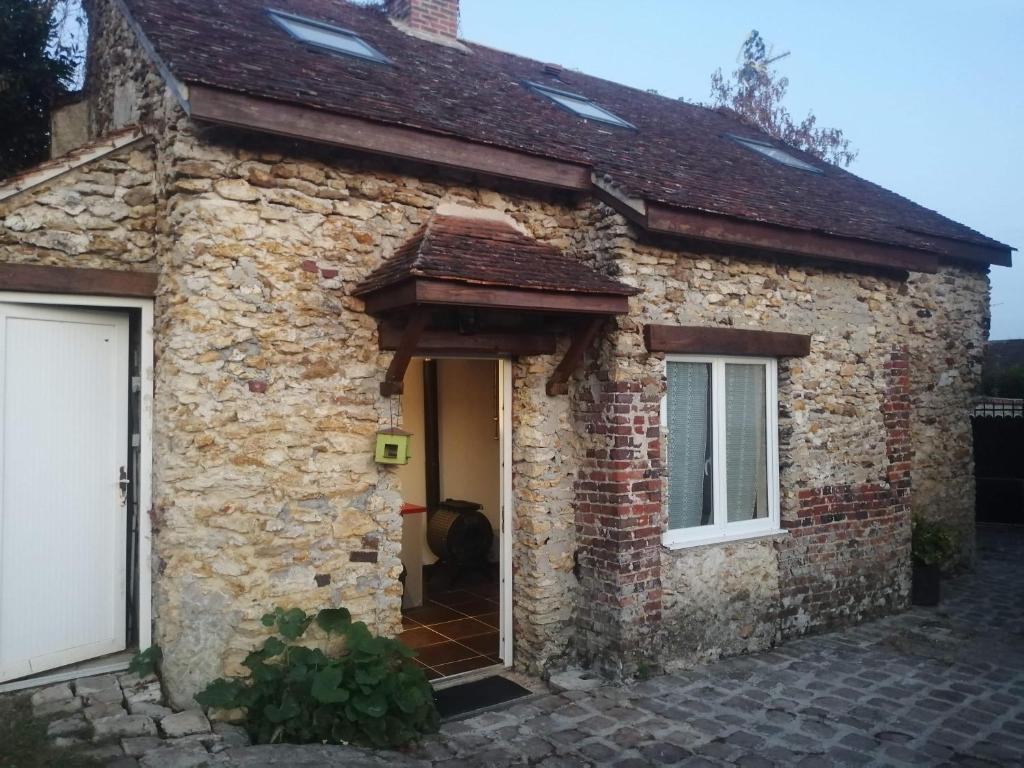 une ancienne maison en pierre avec une porte blanche dans l'établissement la petite briarde, à Boissy-le-Châtel