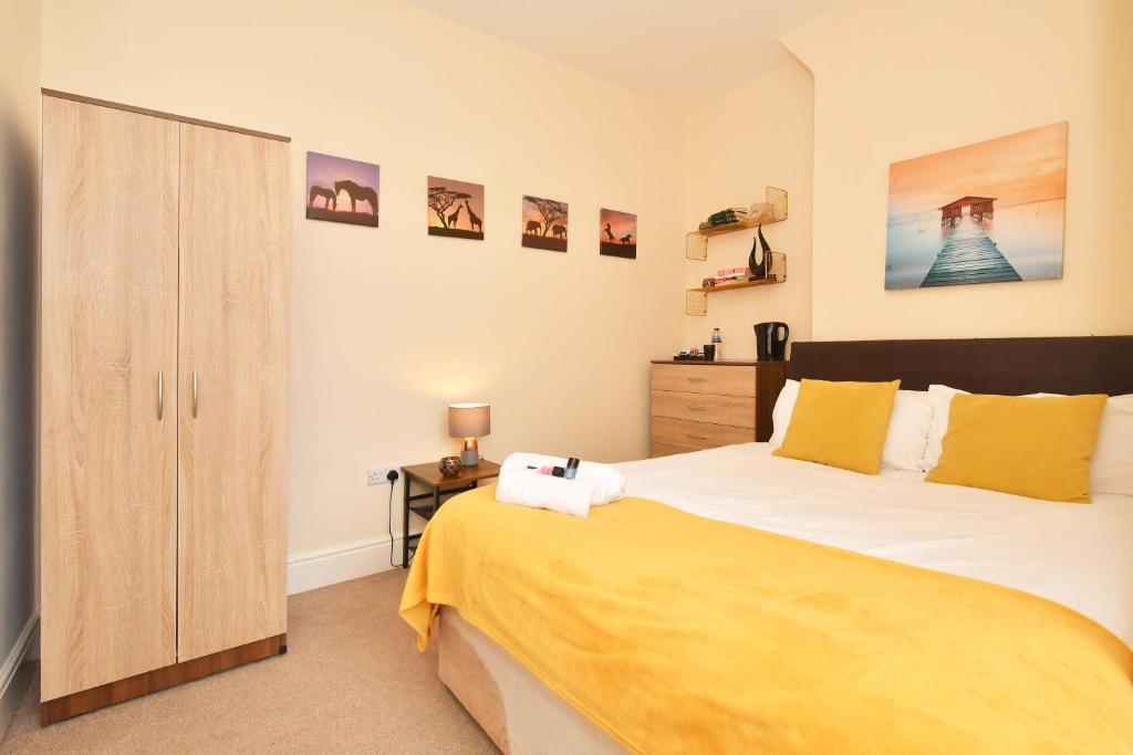 a bedroom with a large bed and a wooden cabinet at Townhouse @ 178 Ruskin Road Crewe in Crewe