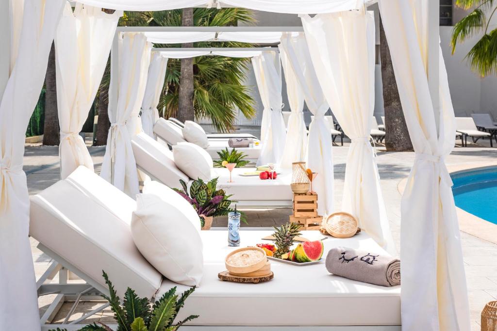a white table with food on it next to a pool at INNSiDE by Meliá Alcudia in Port d'Alcudia