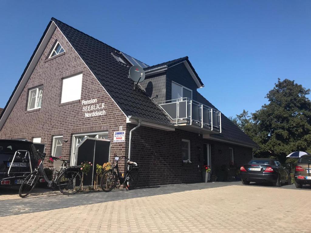a black building with bikes parked outside of it at Pension Seeufer Norddeich in Norddeich