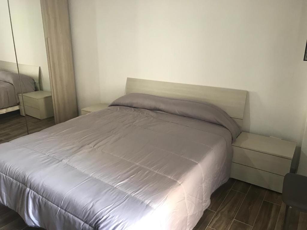 a bedroom with a white bed and a mirror at La Bellavista Mola di Bari in Mola di Bari