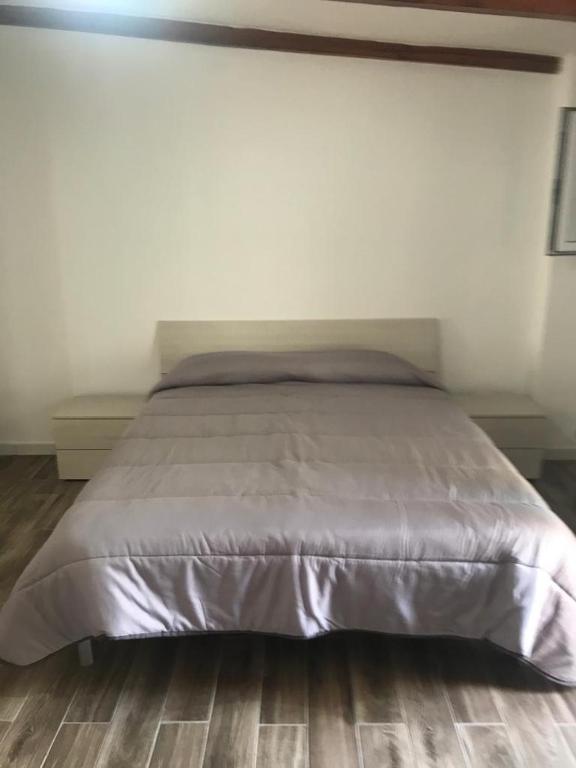 a large bed in a bedroom with a wooden floor at La Bellavista Mola di Bari in Mola di Bari