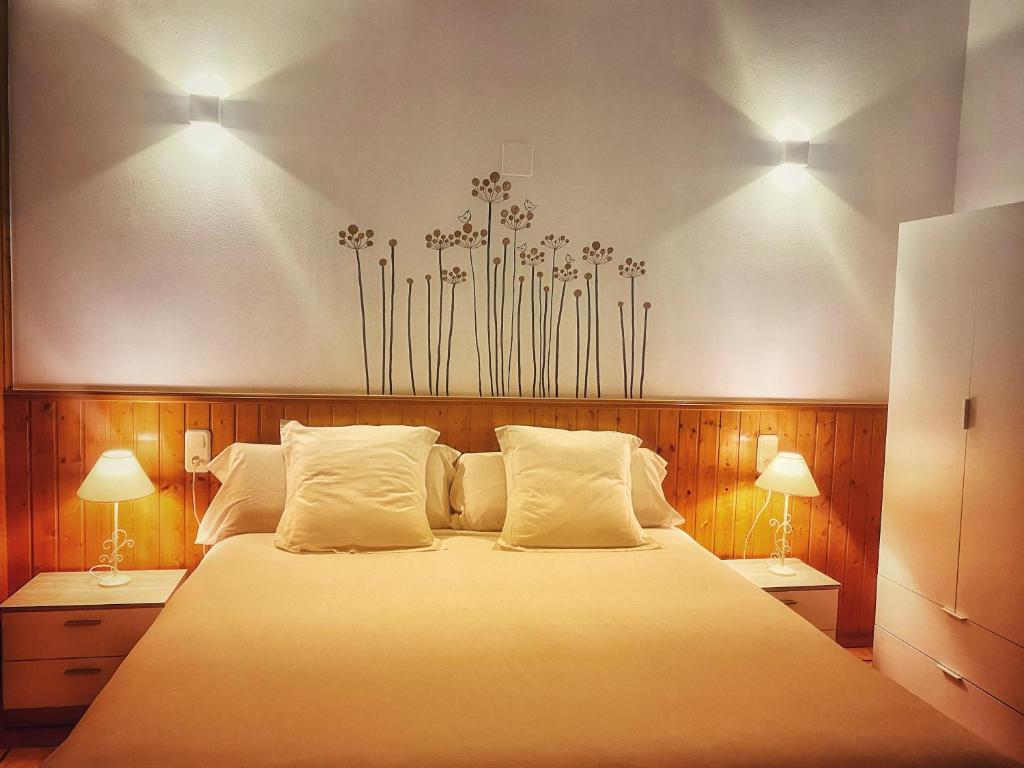 um quarto com uma cama grande e 2 candeeiros em Delta Hotel em Deltebre