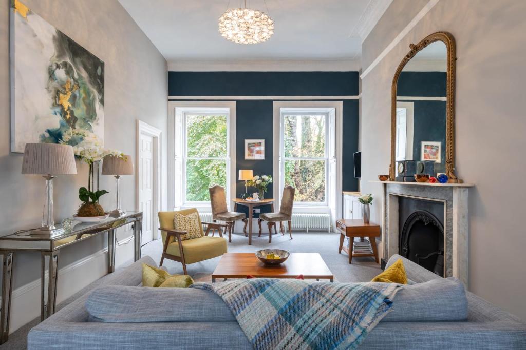 a living room with a couch and a fireplace at Spacious, Light-filled Central Period Apartment in Bath