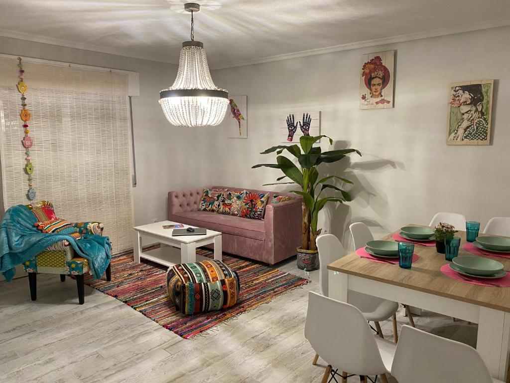 uma sala de estar com um sofá rosa e uma mesa em Enjoy Ávila -LA CATEDRAL em Ávila