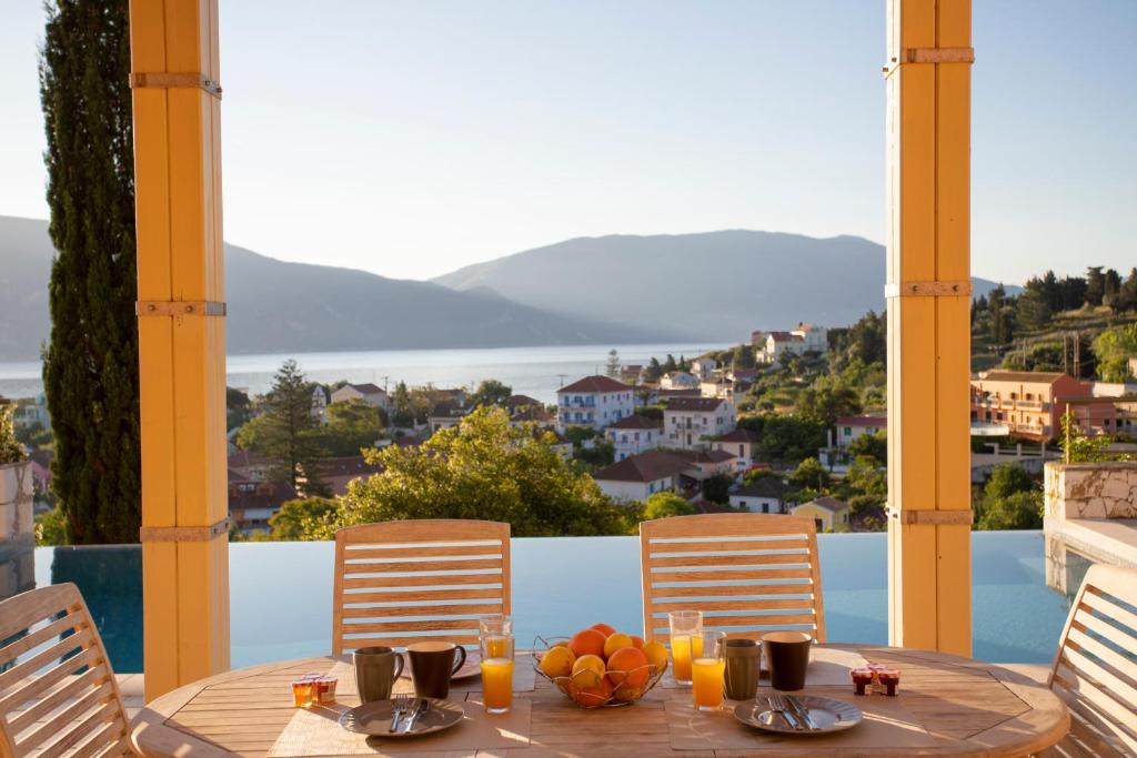 a table with a bowl of fruit on top of a balcony at Fiscardo View Villas in Fiskardo