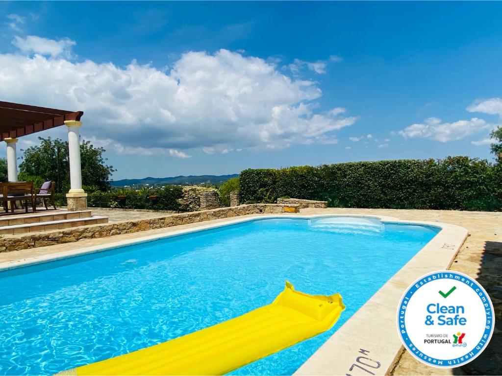 a swimming pool with a yellow inflatable pool noodle in the middle at Portel by Check-in Portugal in São Brás de Alportel