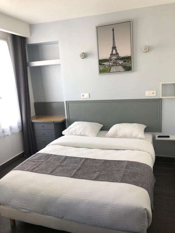 Un pat sau paturi într-o cameră la Hôtel Clauzel Paris
